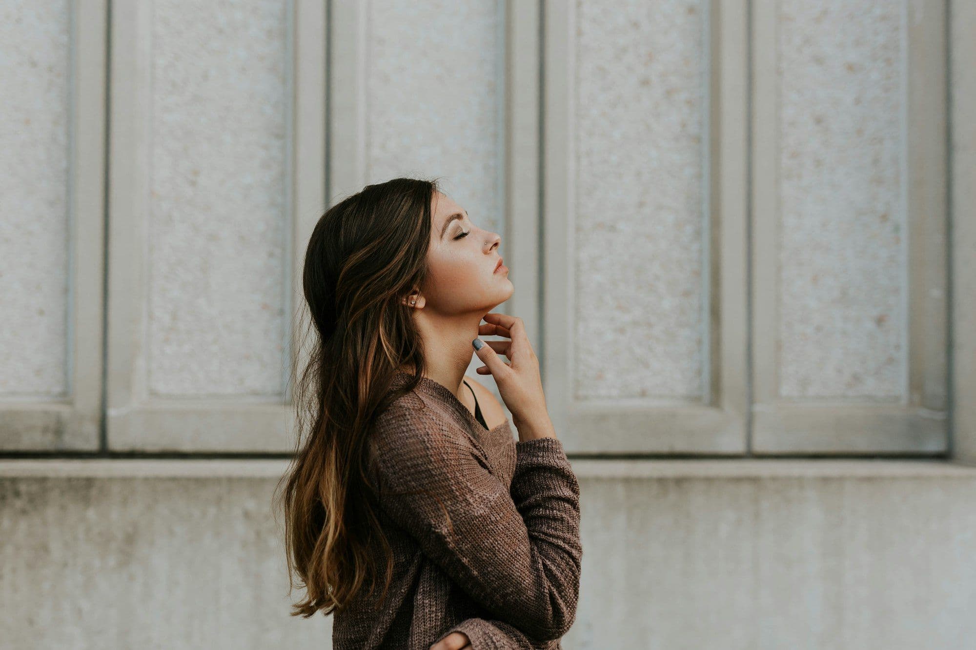 Photograph of a woman in profile, eyes closed, in soft window light