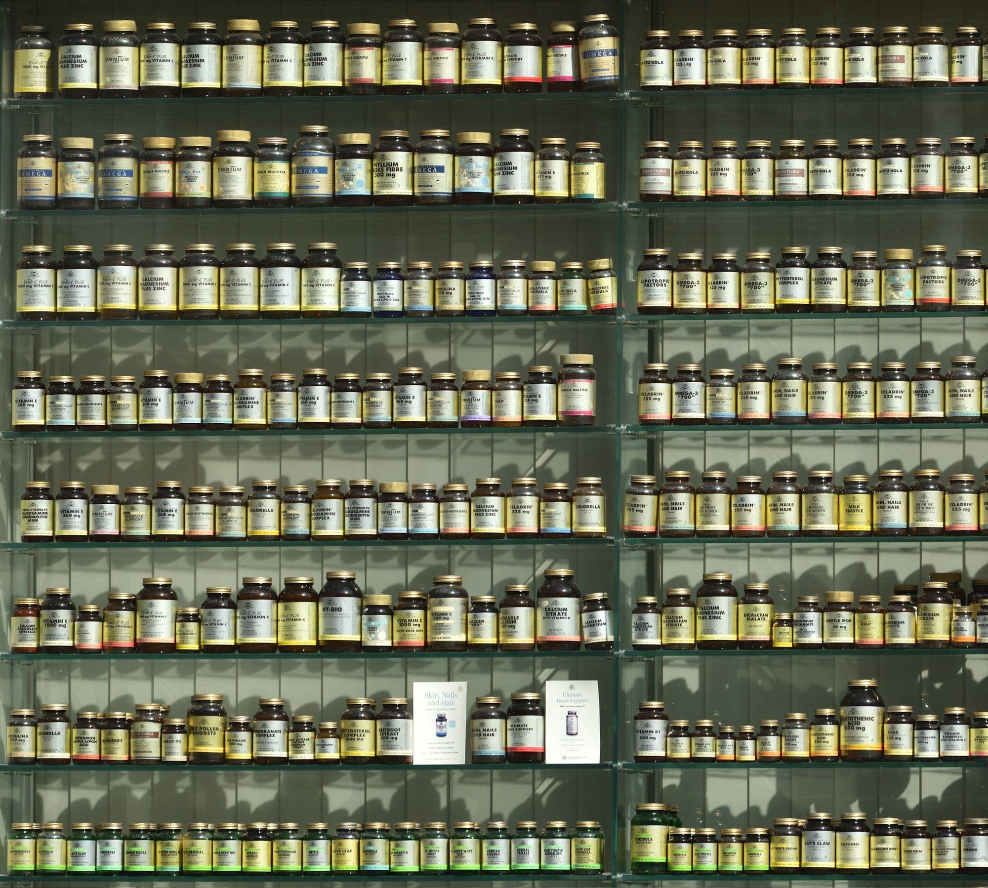 Photograph of shelves packed with rows of supplement bottles
